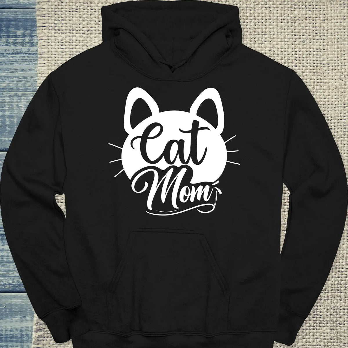 Schwarzer "Cat Mom schnurr - Hoodie" aus weicher Baumwolle mit weißem Aufdruck, verziert mit niedlichen Katzenohren und Schnurrhaaren auf der Vorderseite.